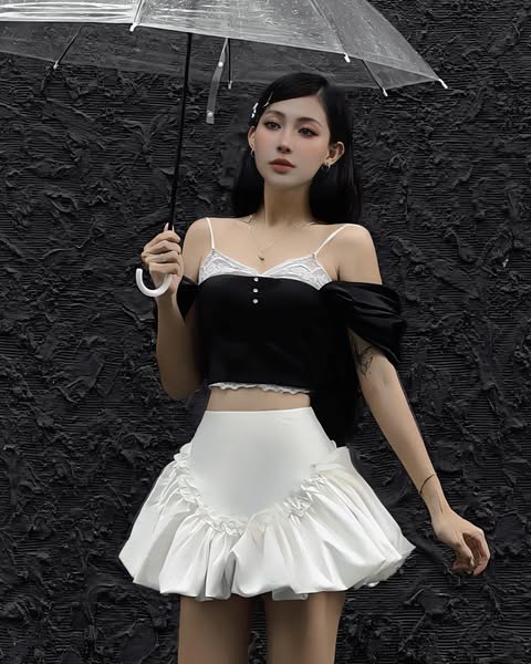 Woman holding a transparent umbrella against a textured black background