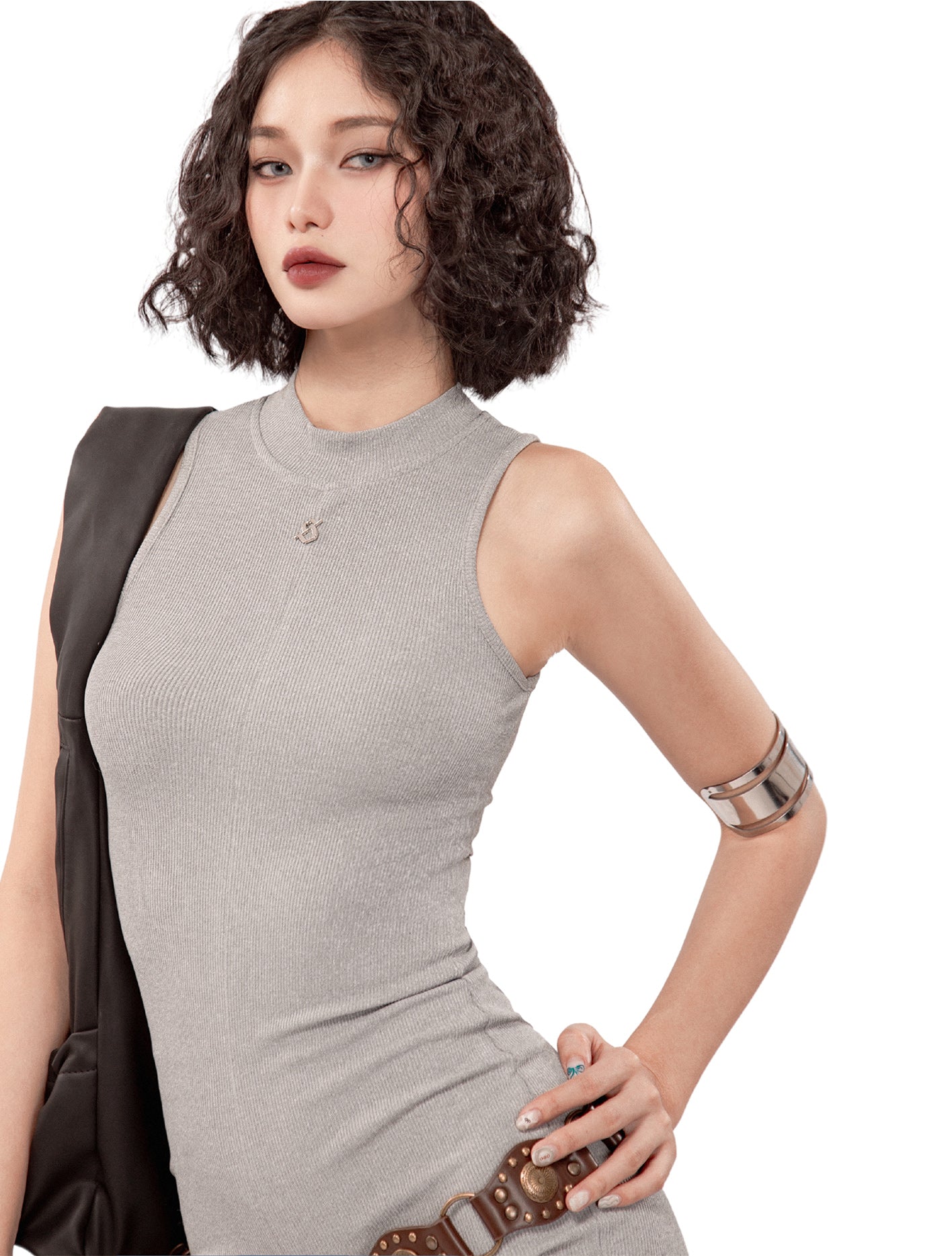 Woman wearing a gray sleeveless dress with a white background