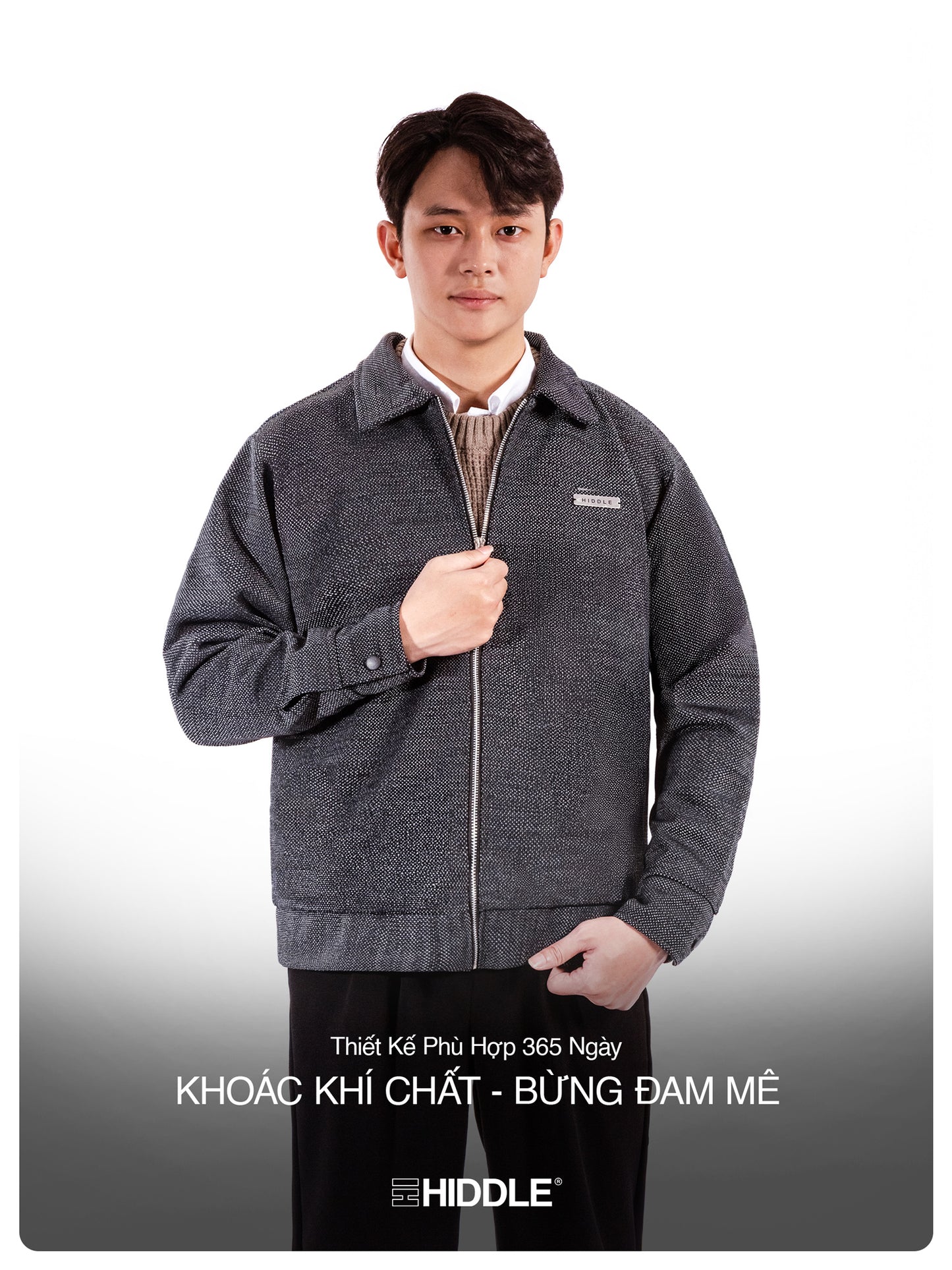 Man wearing a gray jacket with a visible brand logo on a white background