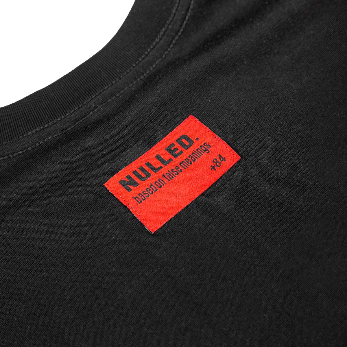 Black t-shirt with a red 'NULLED' label on a white background