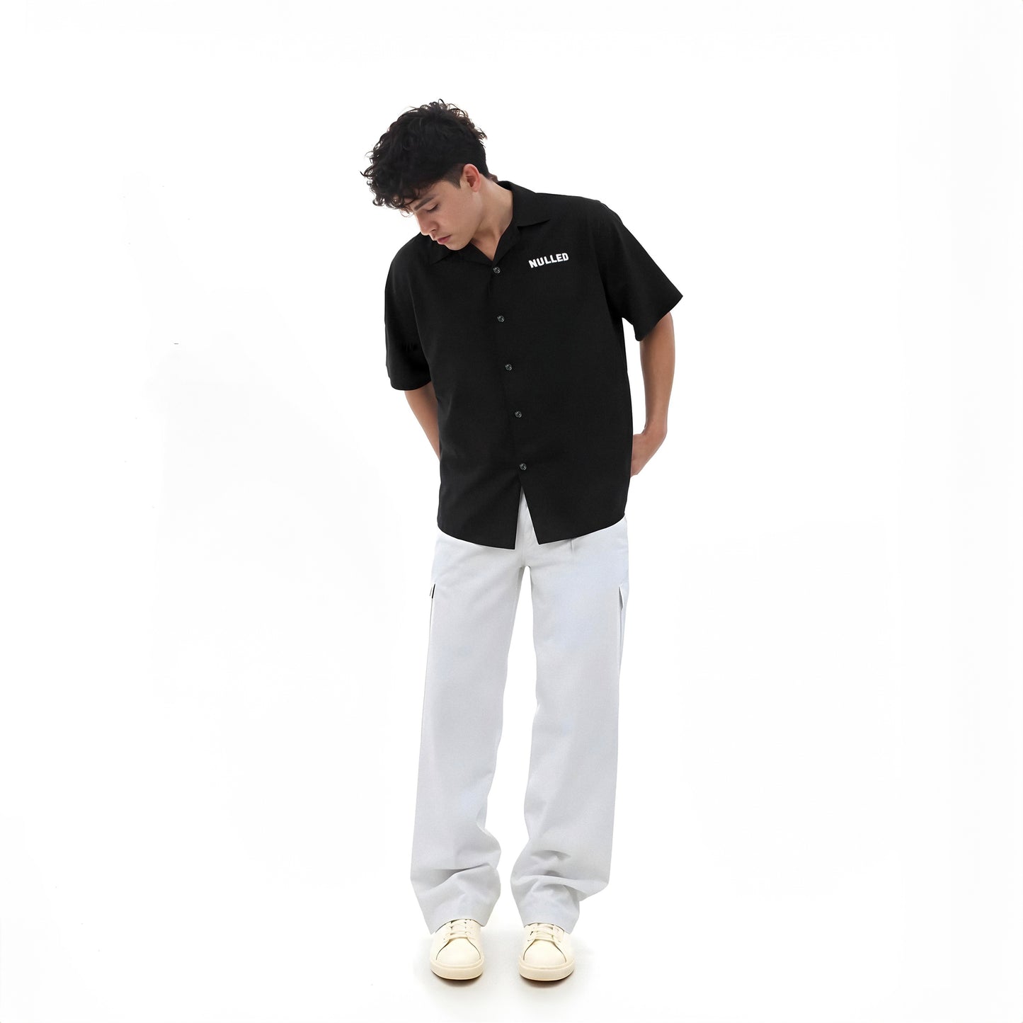 Person wearing a black shirt with a brand logo on a white background