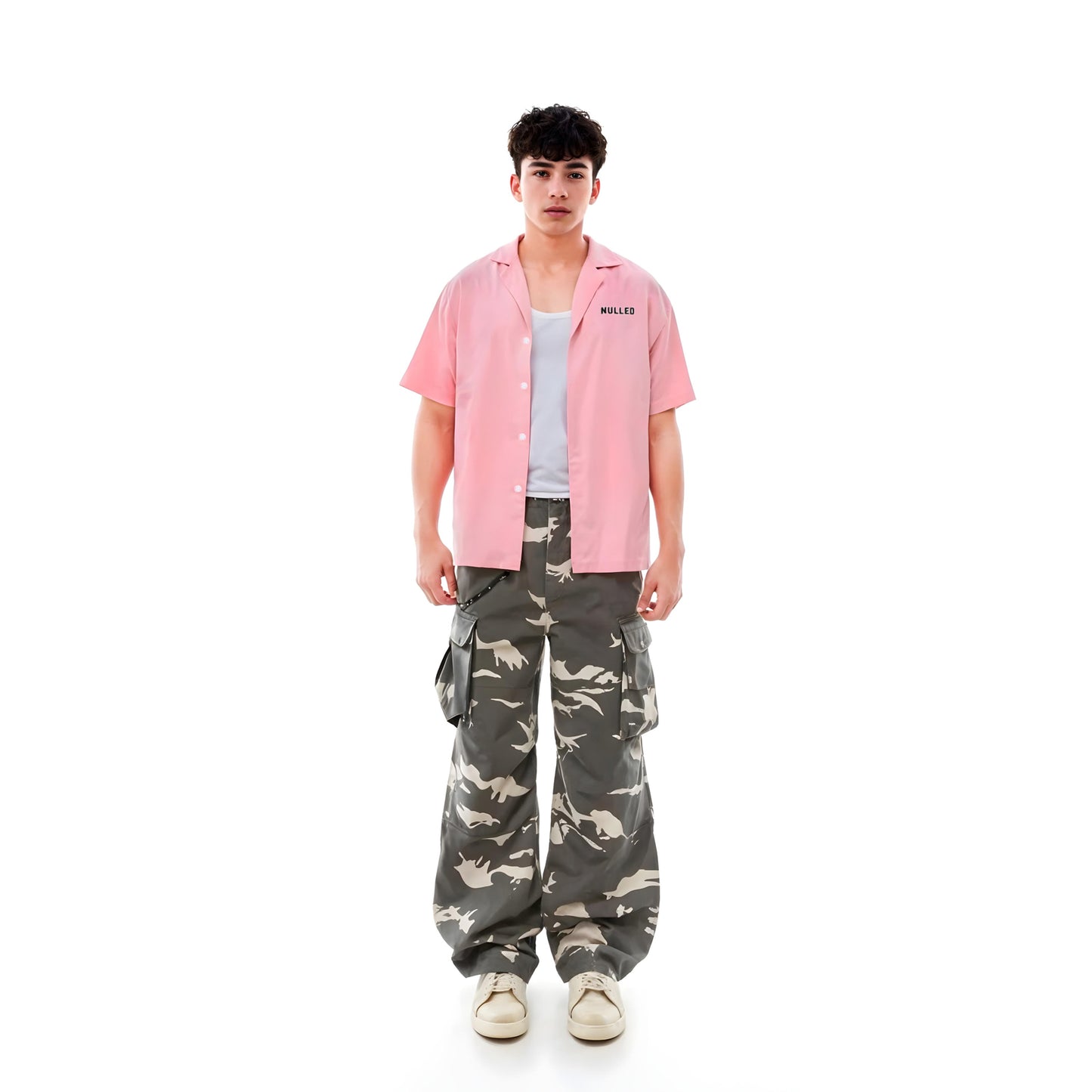 Person wearing a pink shirt and camouflage pants on a white background