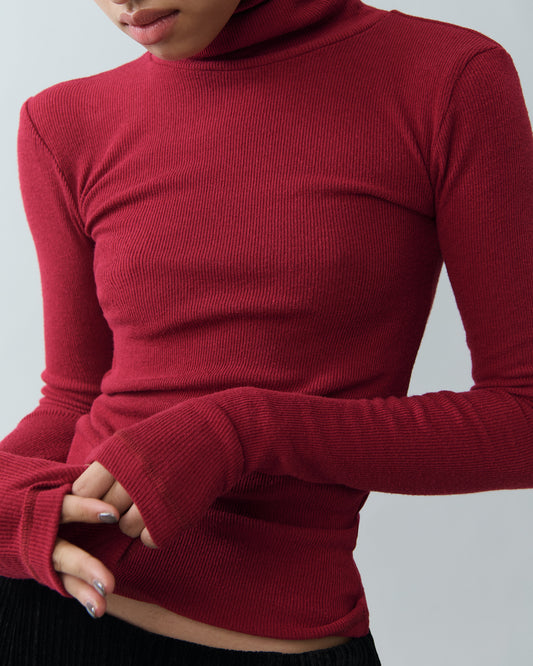 Model wearing red high-neck ribbed top