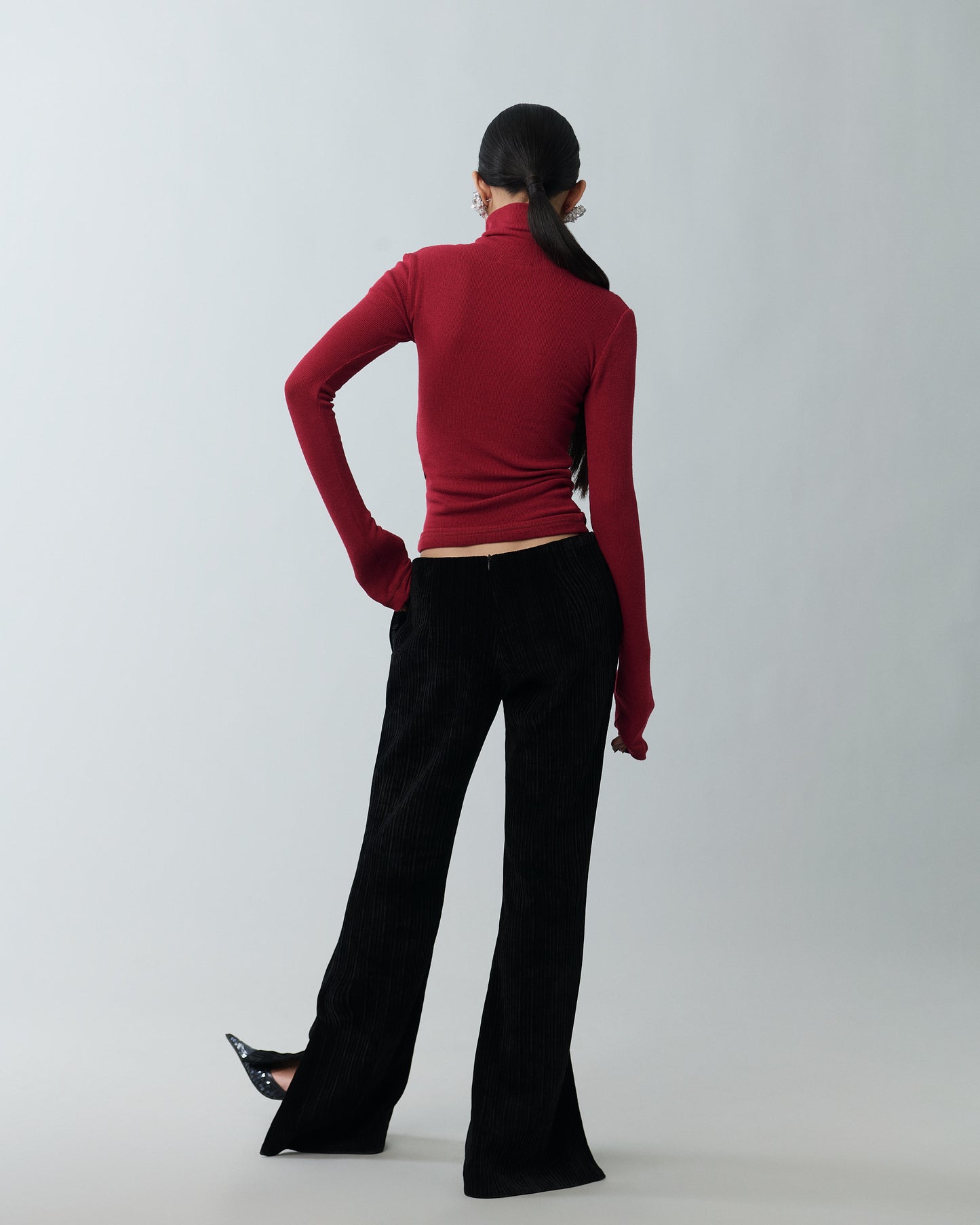 Model styling black velvet pants with heels