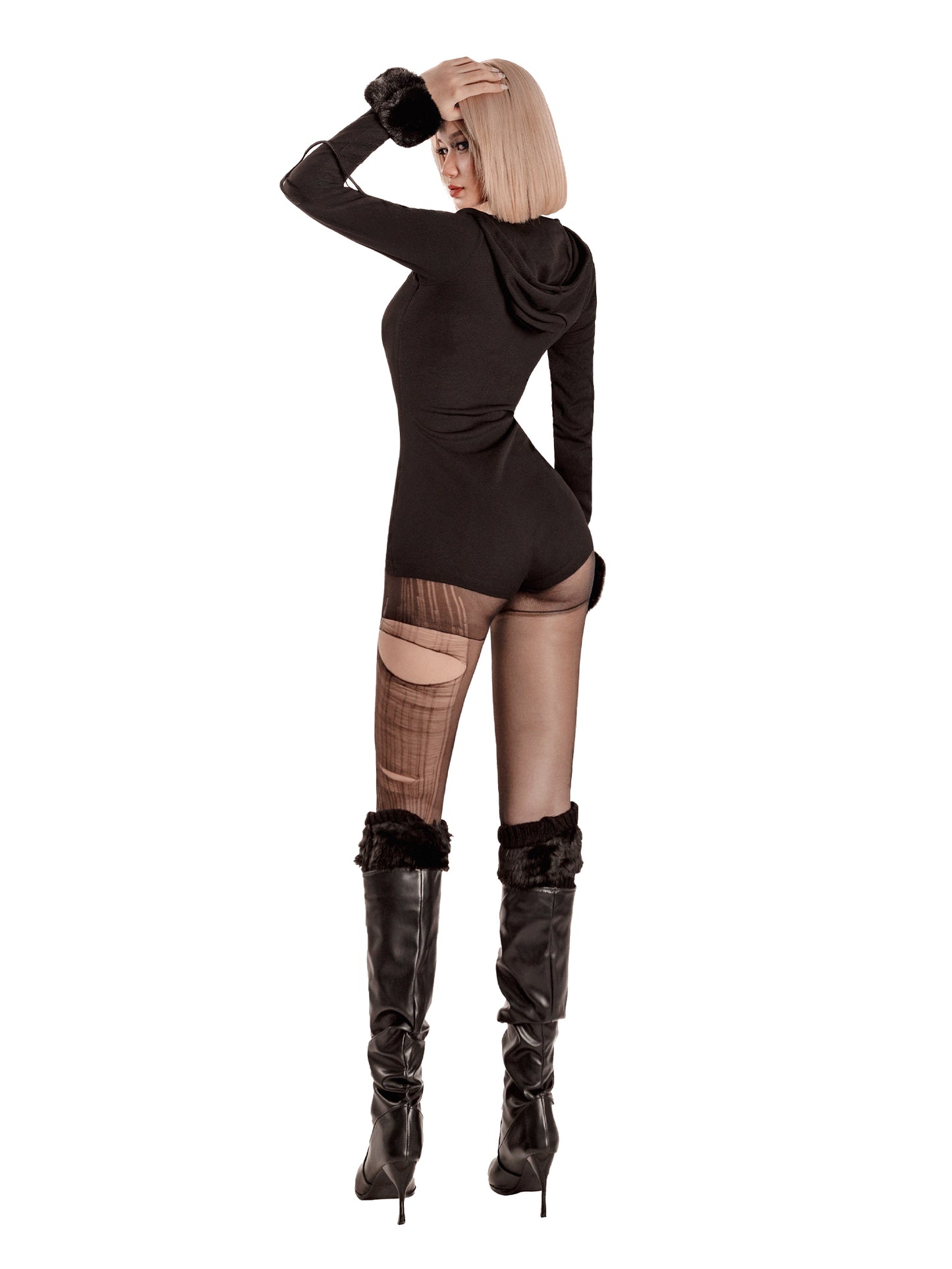 Woman wearing a black bodysuit with fishnet stockings and high boots on a white background