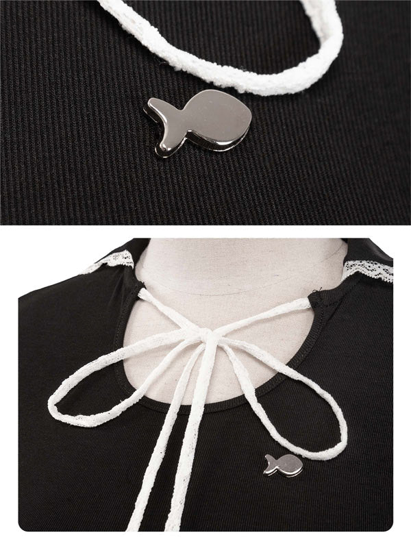 Black top with white lace-up design and silver fish-shaped pendant on a black background