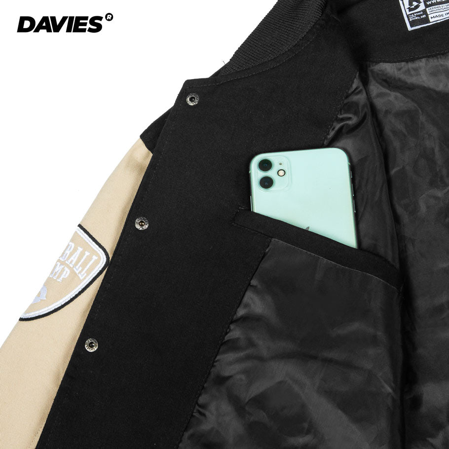 Close-up of a black and beige jacket with a phone in the pocket, featuring the Davies brand.