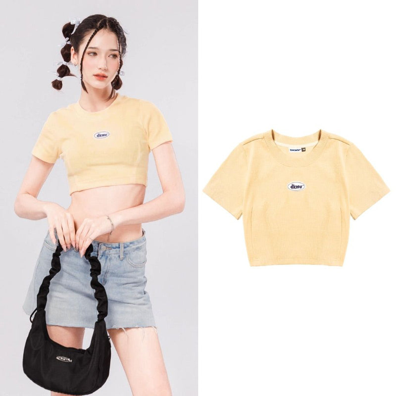 Woman wearing a yellow crop top with a brand logo, standing next to the same top on a white background.