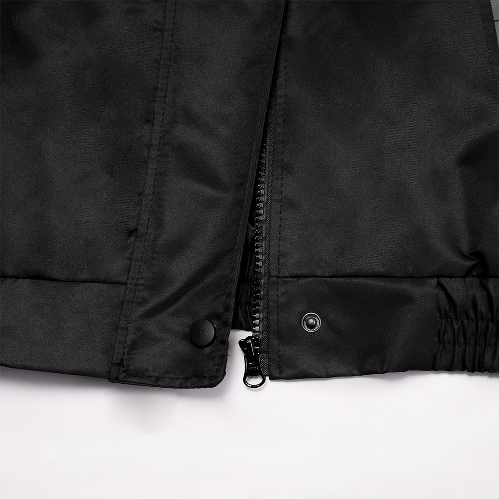 Close-up of a black jacket with buttons and a zipper on a white background