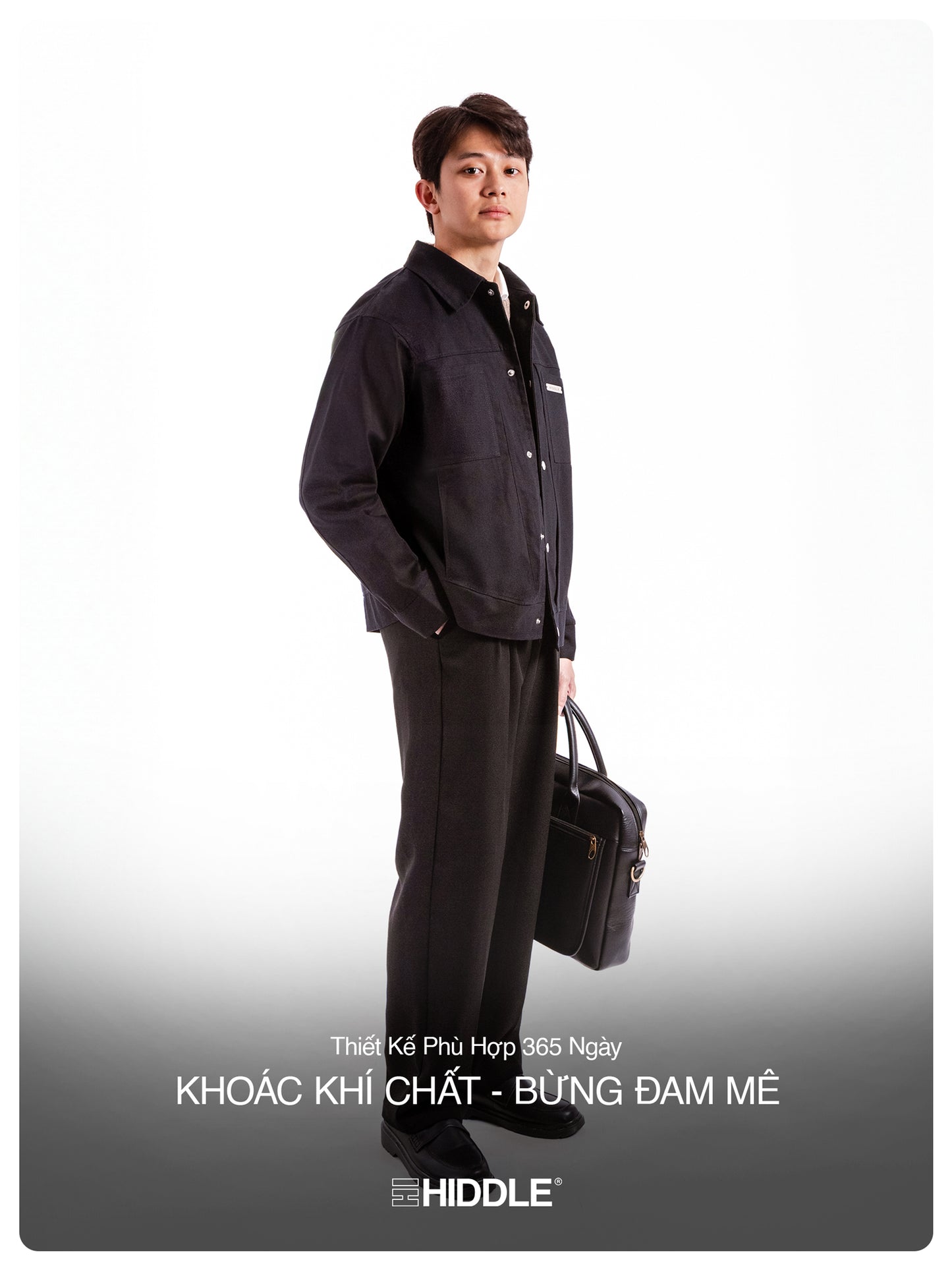 Man wearing a black outfit with a briefcase, standing against a white background, featuring the brand 'Hiddle'.