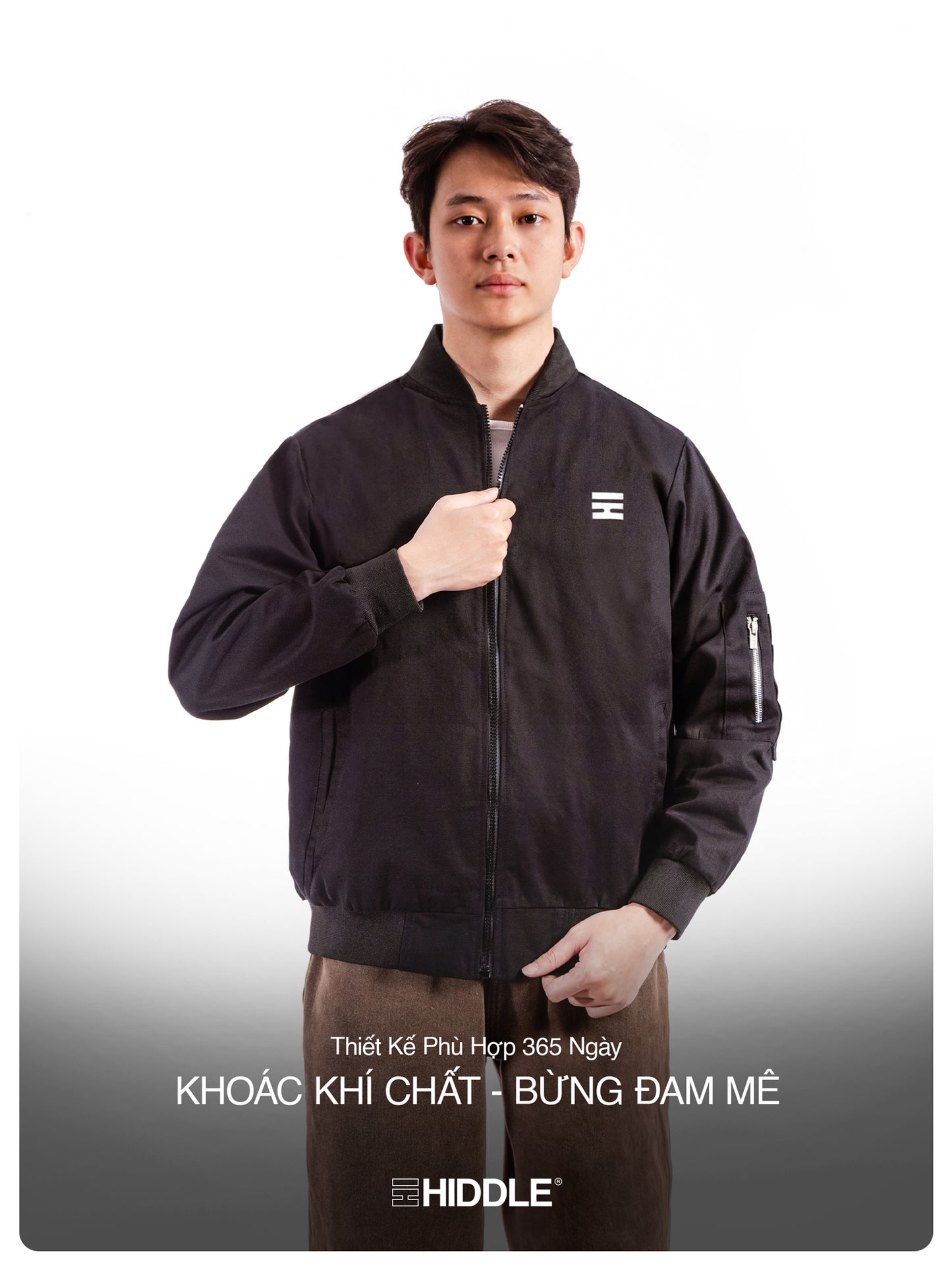 Man wearing a black jacket with a visible brand logo on a white background
