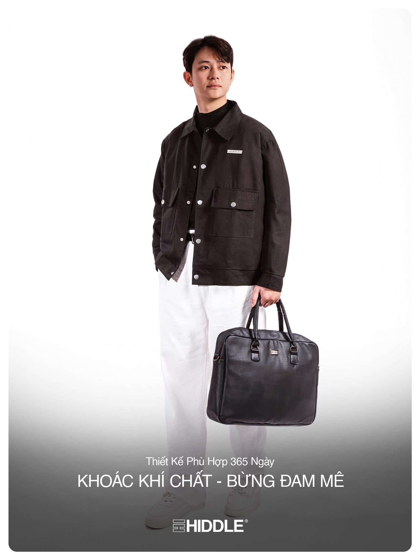Man holding a black leather bag with Hiddle branding on a white background