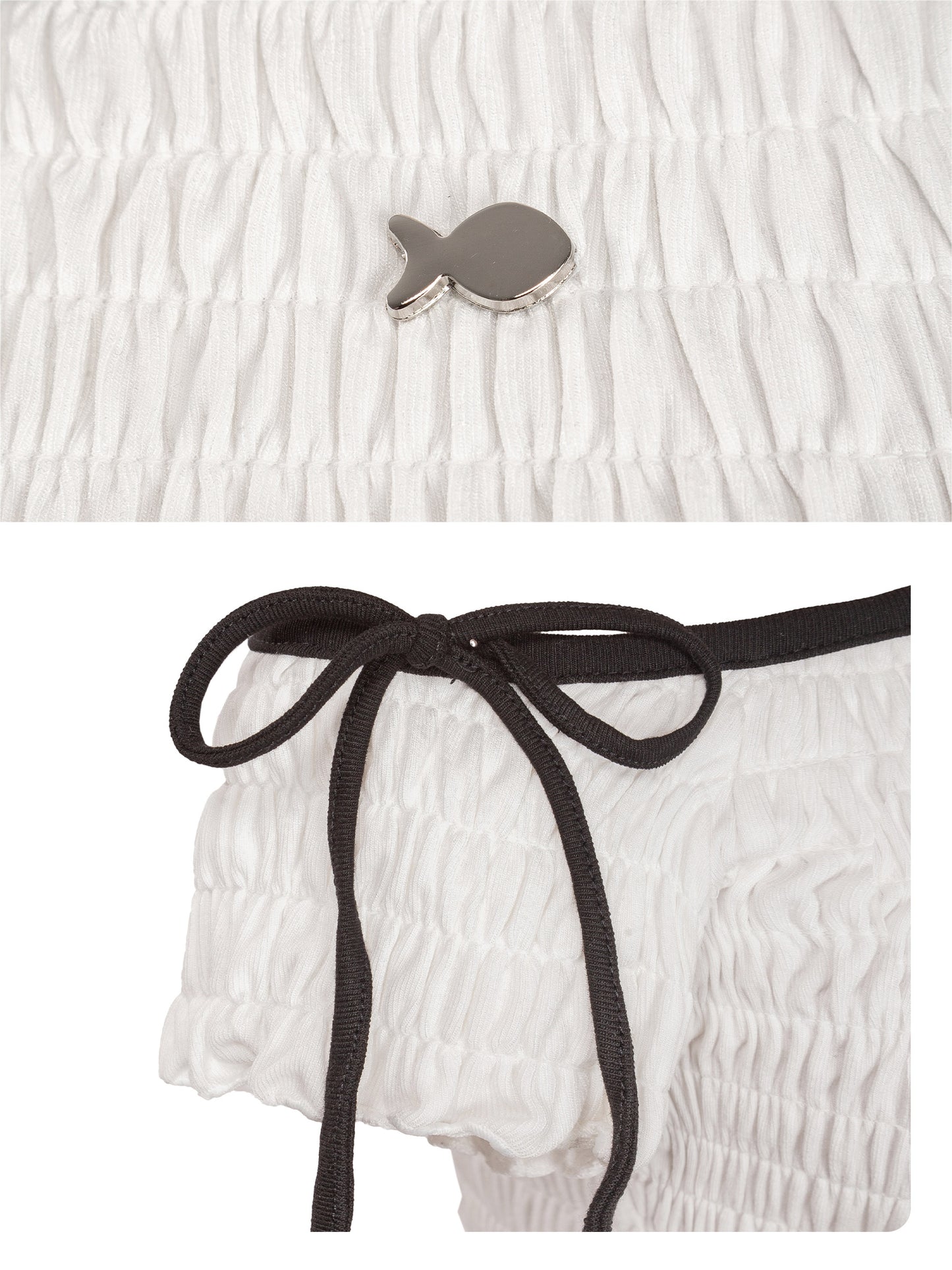 White textured fabric with a small fish-shaped brooch and a white garment with a black ribbon.