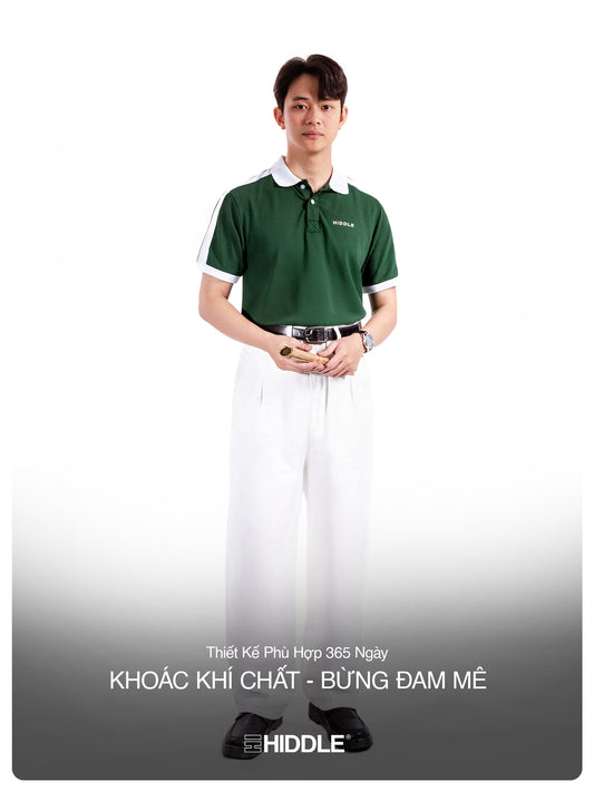 Person wearing a green polo shirt and white pants on a white background with Hiddle branding.