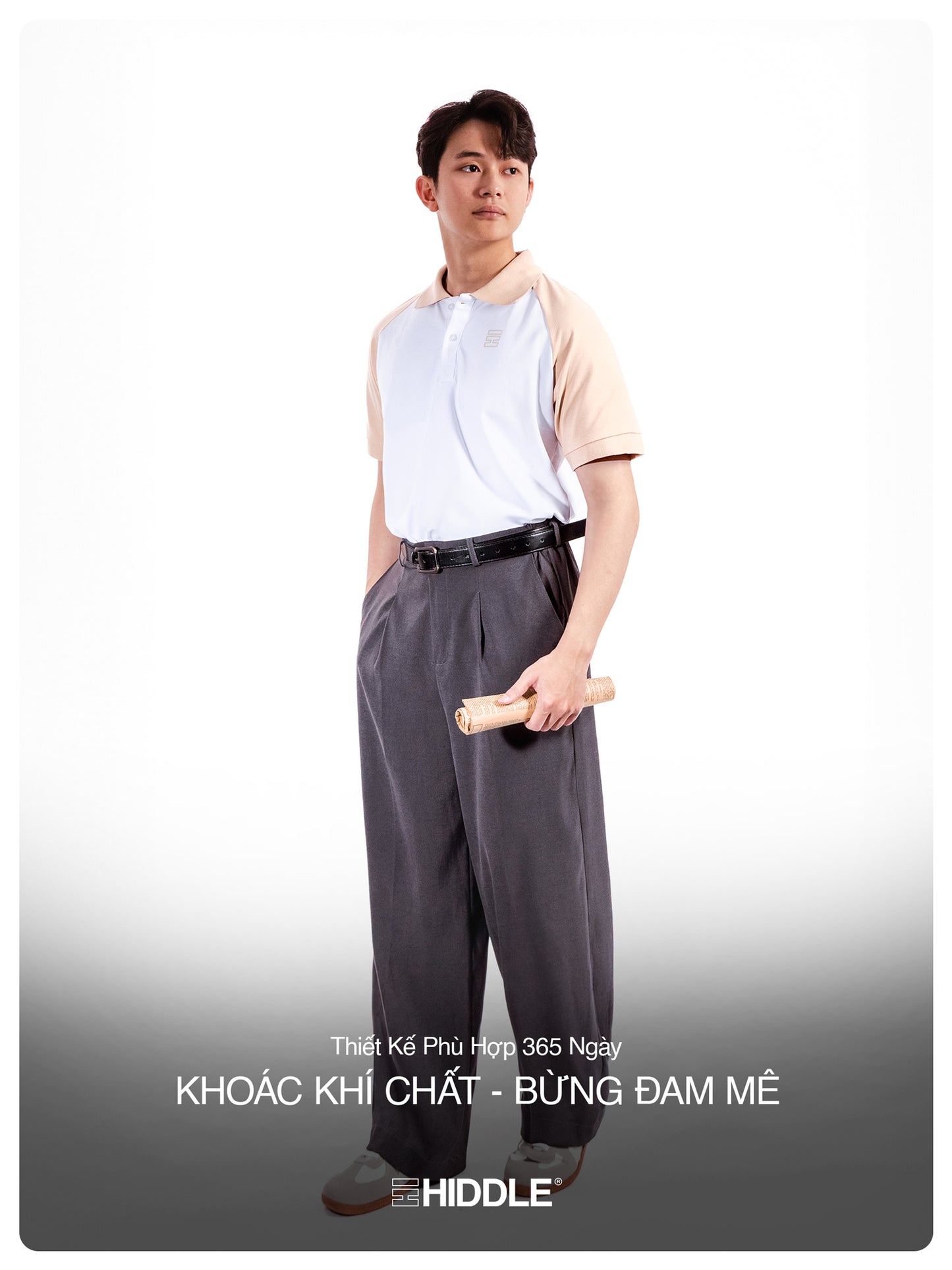 Man wearing a white shirt and gray pants holding a rolled-up paper on a white background