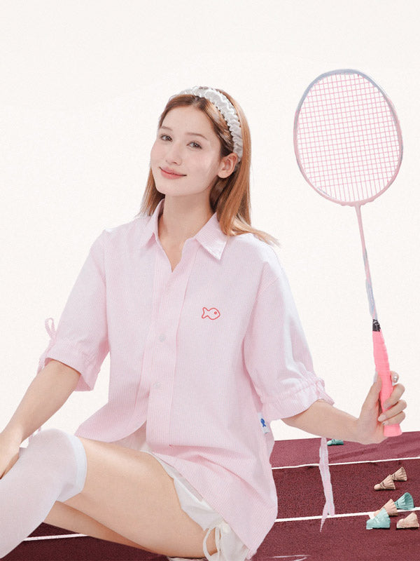 Woman in pink outfit holding a badminton racket on a sports court