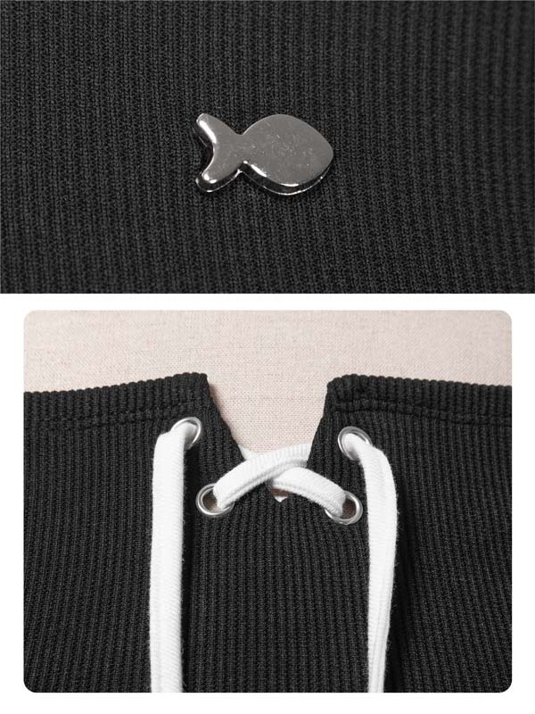 Close-up of a black textured fabric with a metal clip and white drawstrings.
