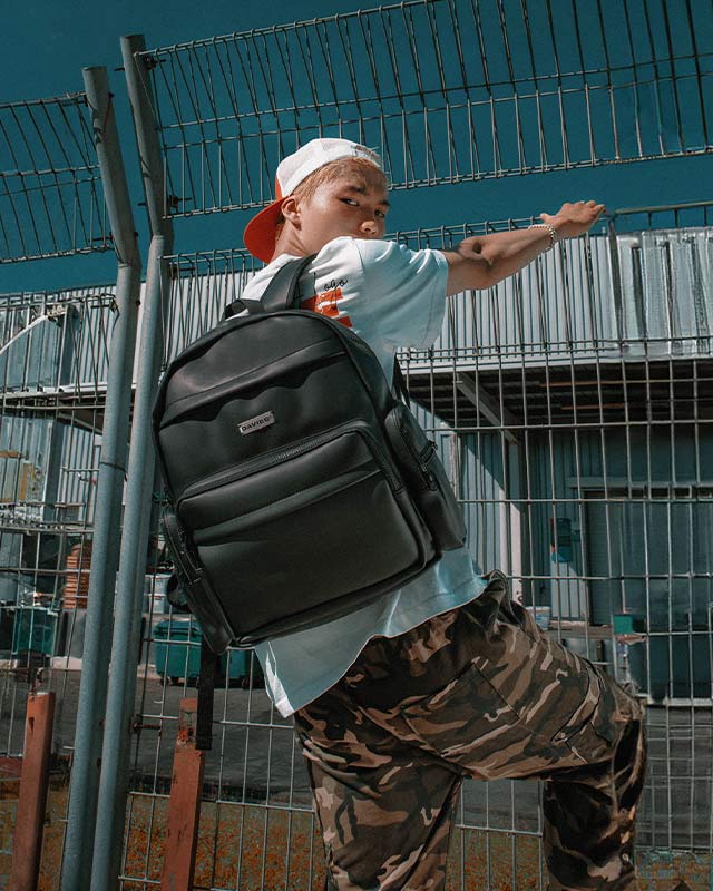 Person wearing a black backpack in an industrial setting