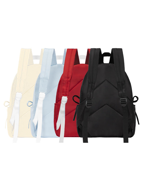 Black backpack among other colorful bags on a white background