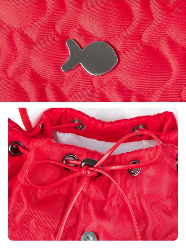 Close-up of a red bag with a metal fish-shaped tag and drawstring.