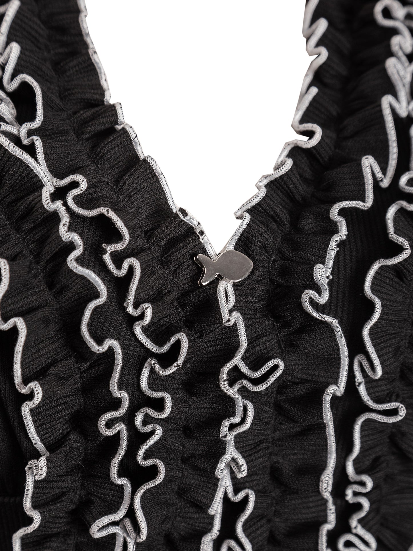 Close-up of a black textured fabric with white decorative patterns on a white background