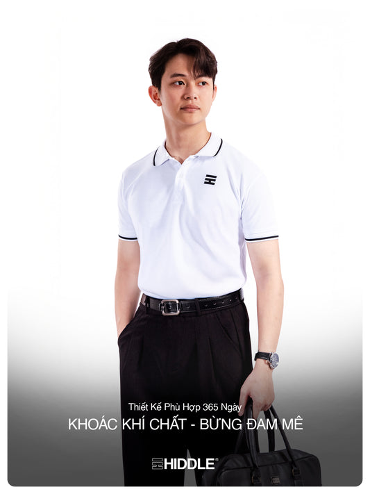 Man wearing a white polo shirt with a logo, black pants, and carrying a black bag on a white background.