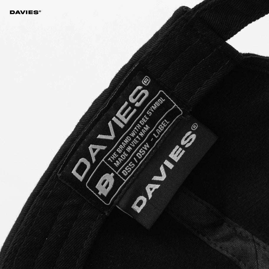Close-up of Davies brand labels on a black fabric background