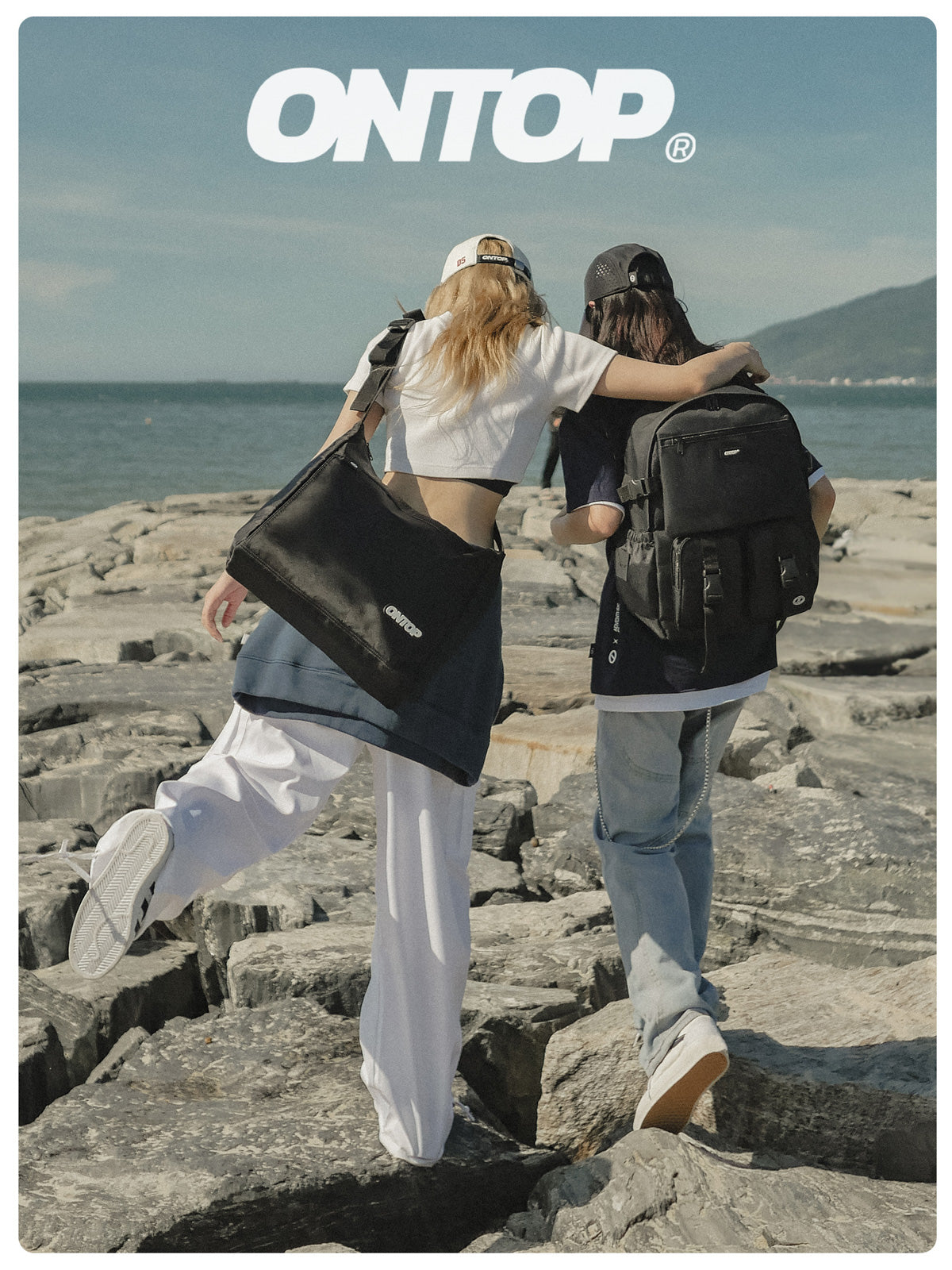 Two people with black backpacks on a rocky shoreline with 'ONTOP' branding.