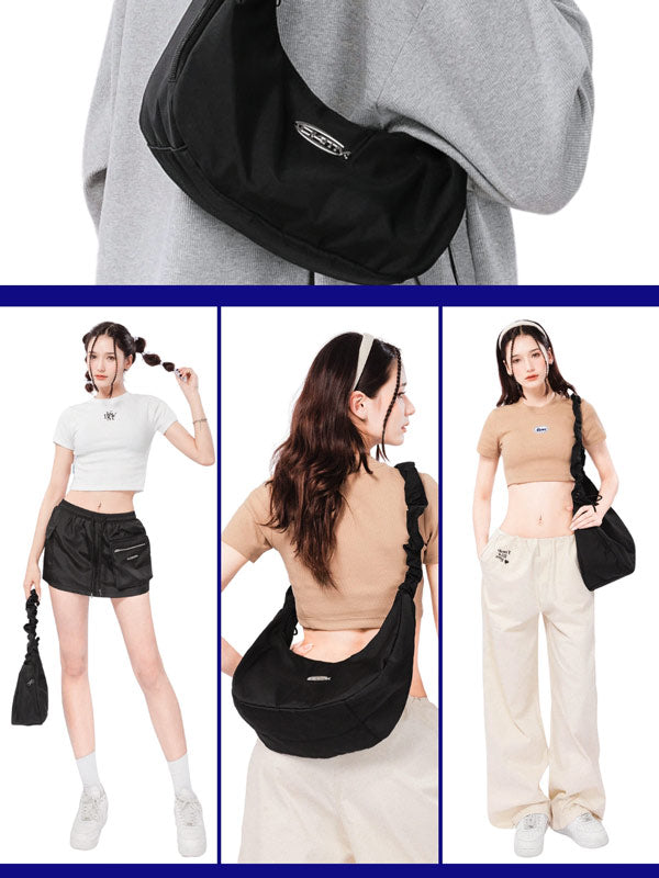 Black waist bag worn by a person with a gray hoodie, displayed on a white background.