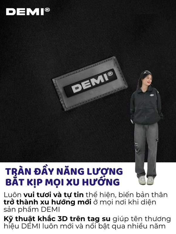 Person wearing a black jacket with a DEMI logo patch on a dark background