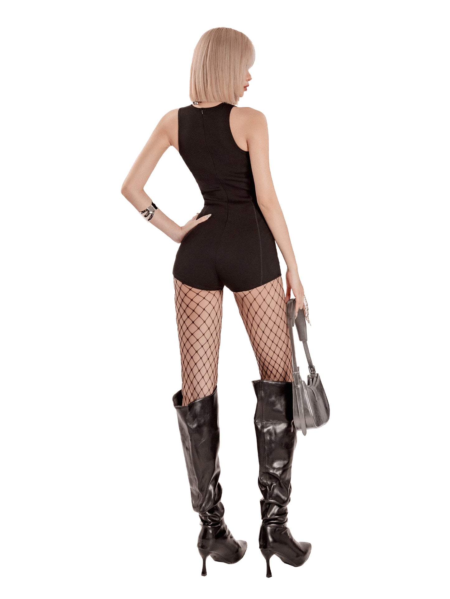 Woman in black sleeveless top and shorts with fishnet stockings and high boots on a white background