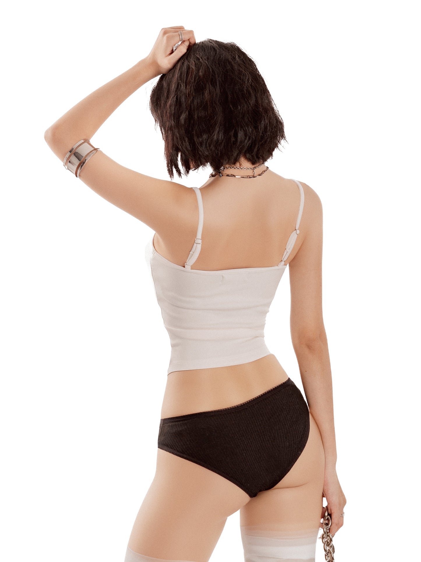Woman wearing a white tank top and black underwear on a white background