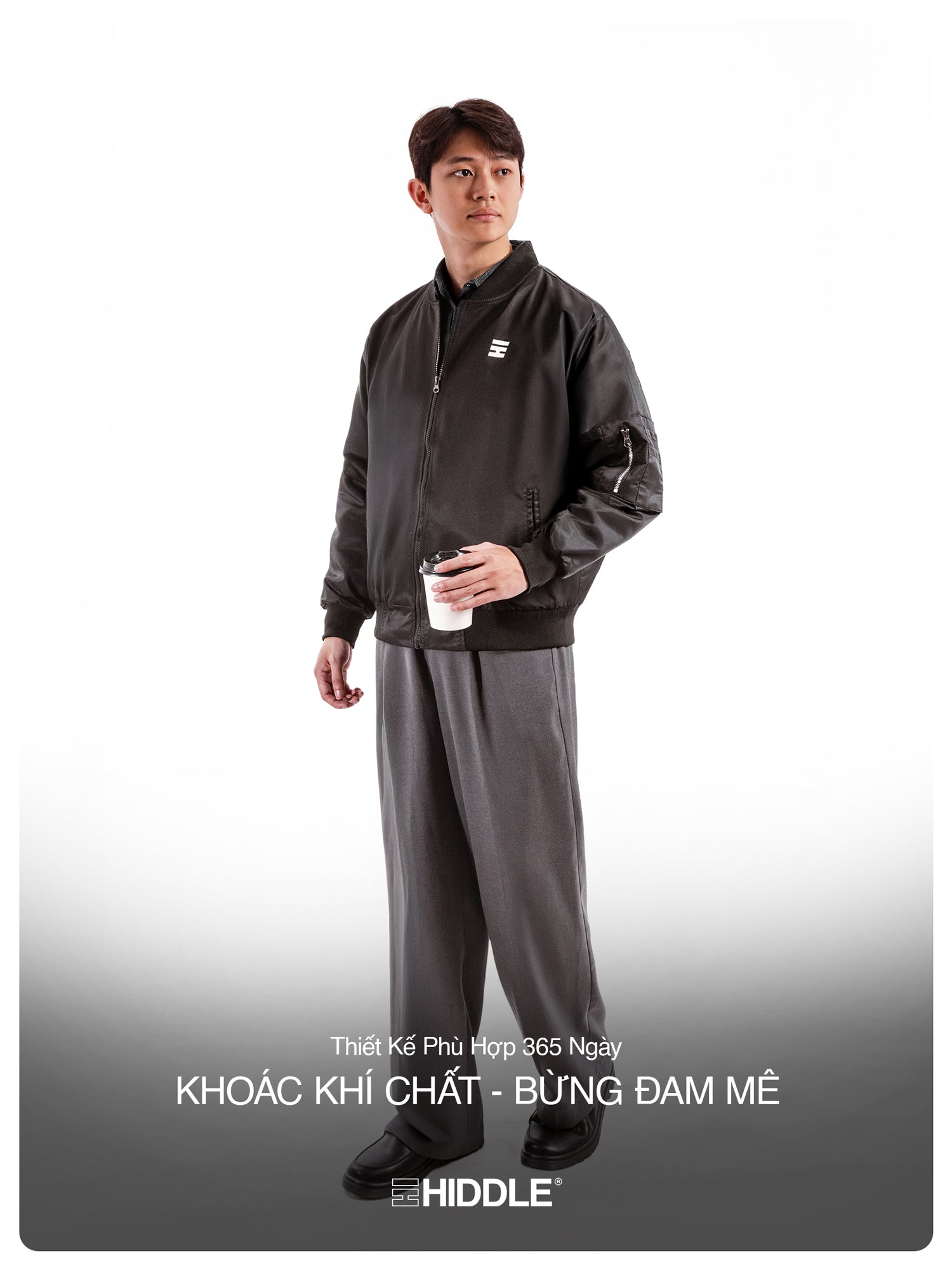 Person wearing a black tracksuit with a visible brand logo on a white background