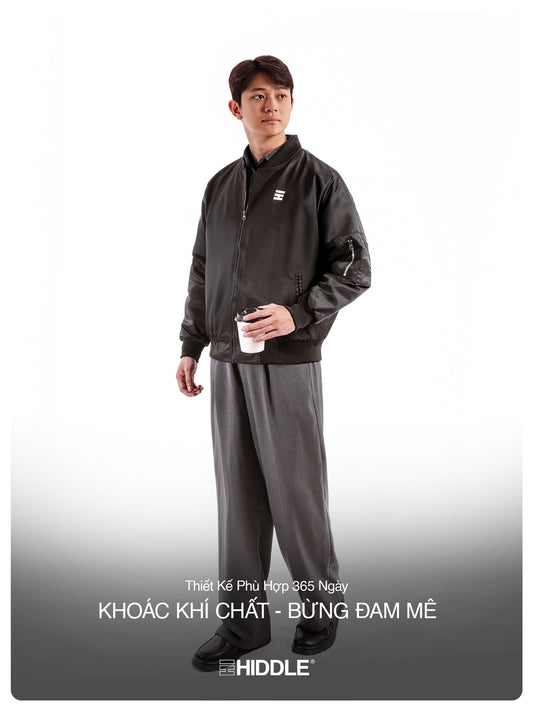 Person wearing a black tracksuit with a visible brand logo on a white background