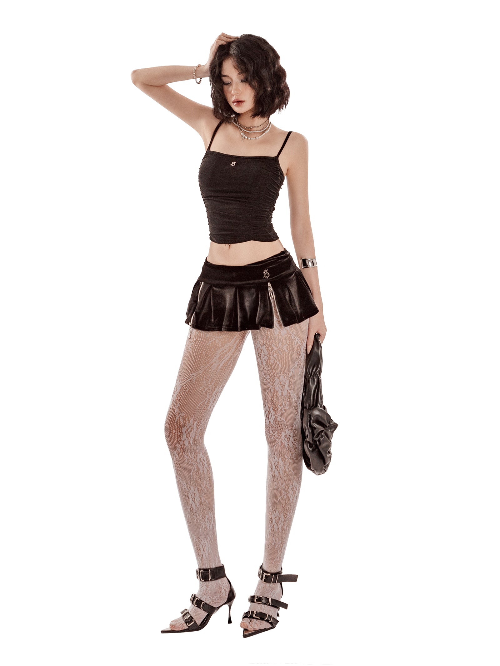 Woman wearing a black top, leather skirt, fishnet stockings, and high-heeled shoes on a white background