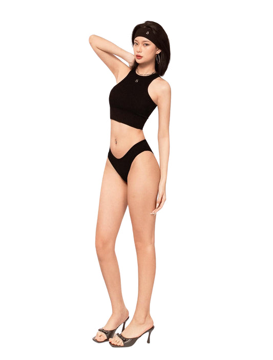Woman wearing a black bikini and headscarf on a white background