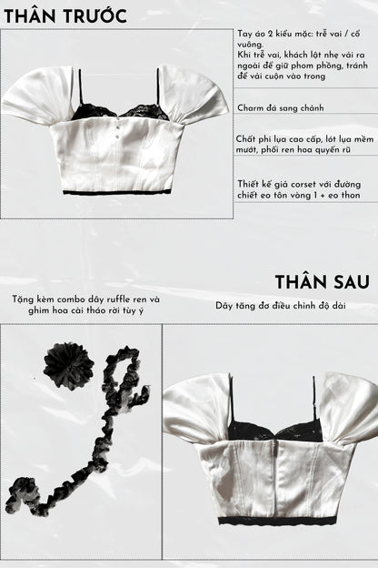 White satin top with black lace details on a gray background