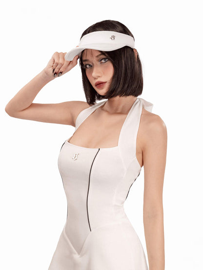 Woman wearing a white dress and visor against a white background