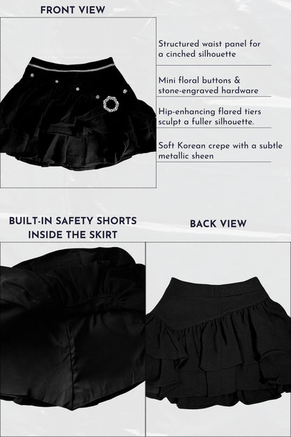 Black skirt with structured waist panel, mini floral buttons, and built-in safety shorts on a white background.