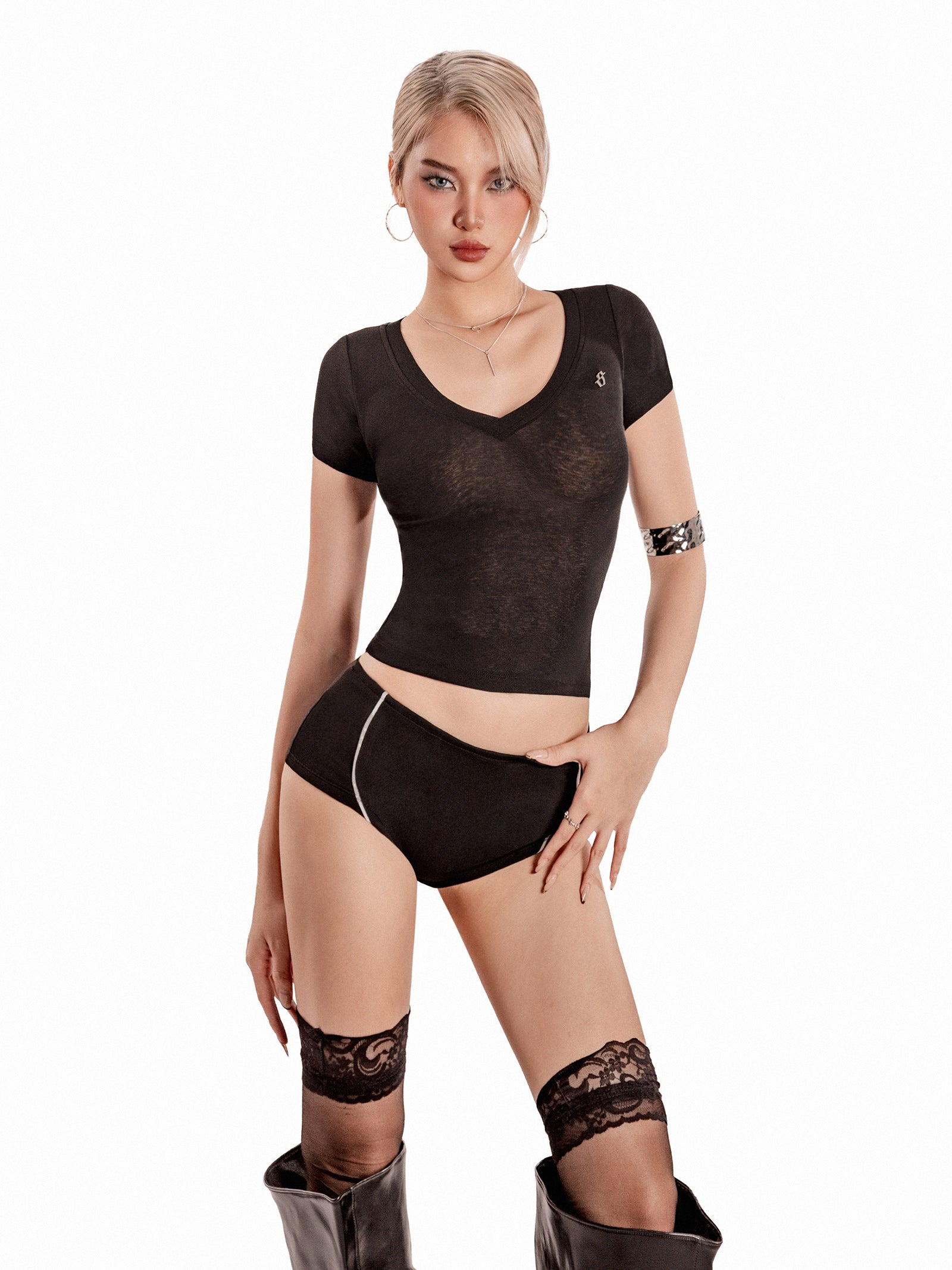 Woman wearing a black lingerie set with lace details on a white background