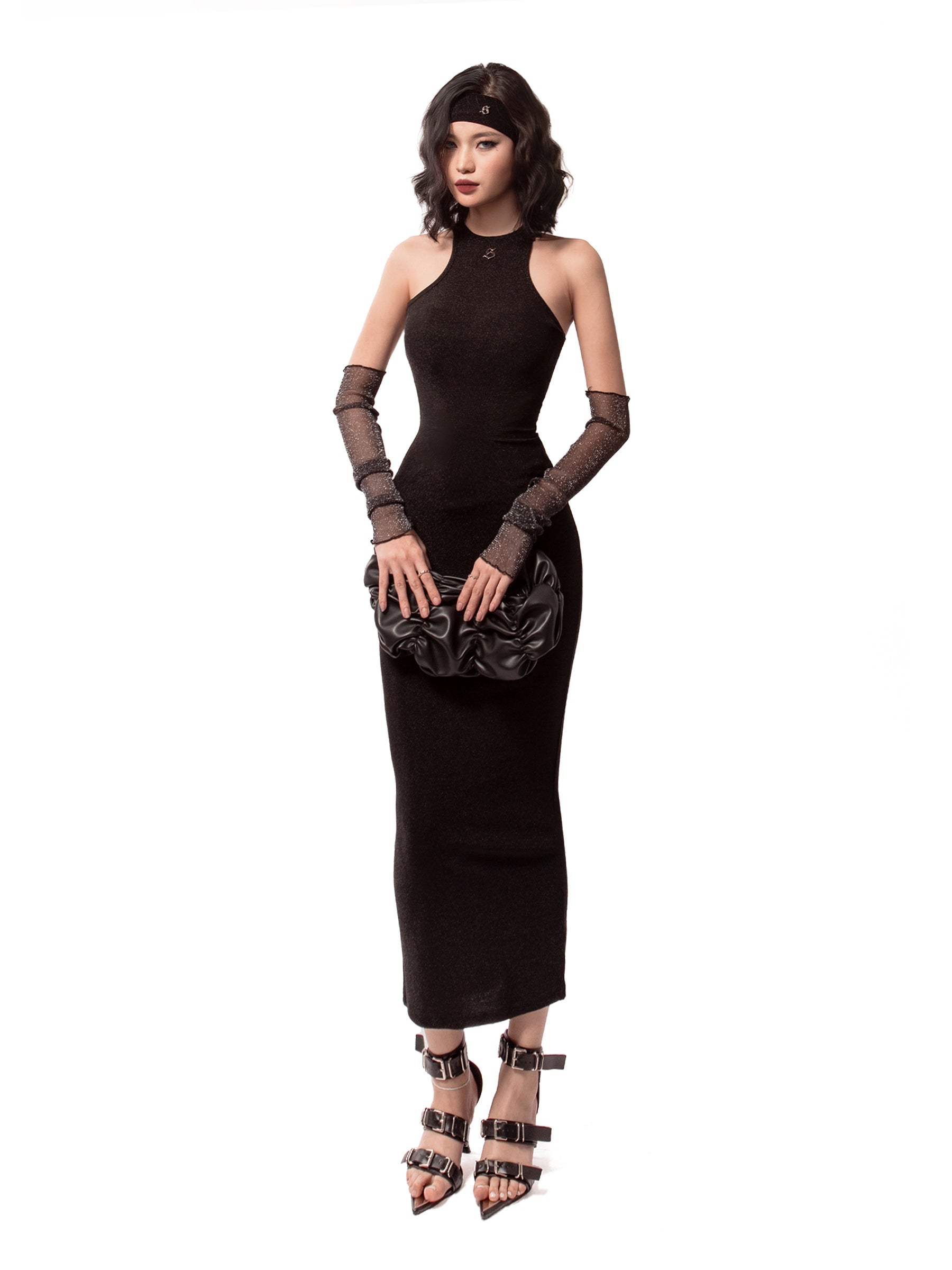 Woman wearing a black dress with long gloves and high heels on a white background