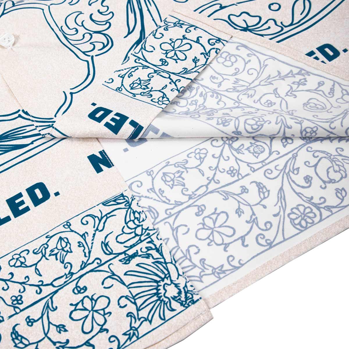 White fabric with blue floral and geometric patterns, folded and displayed.