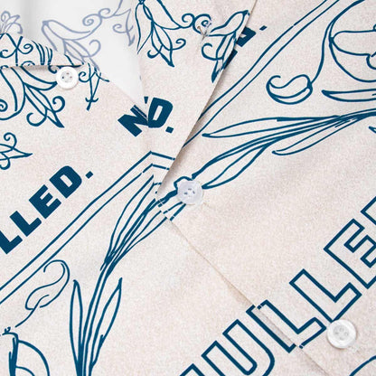 Close-up of a shirt with blue floral and text design on beige fabric.
