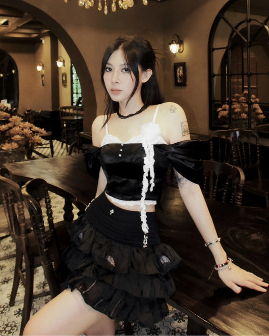 Woman in a black and white outfit sitting in a restaurant.