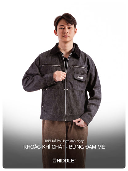 Man wearing a dark denim jacket with visible branding on a gray background