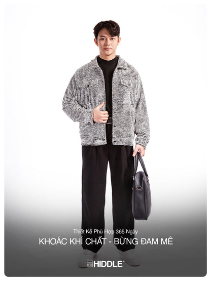 Man wearing a gray jacket and black pants holding a bag on a white background