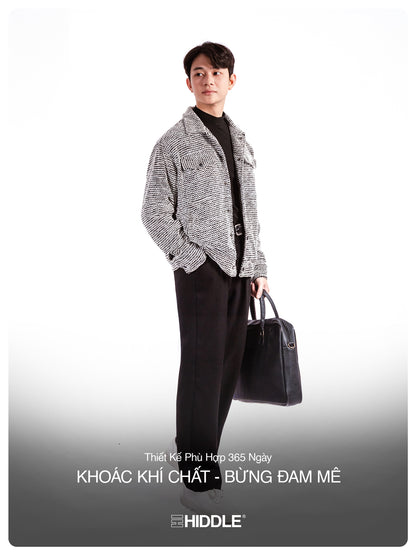 Man holding a black briefcase with 'Hiddle' branding on a gray background
