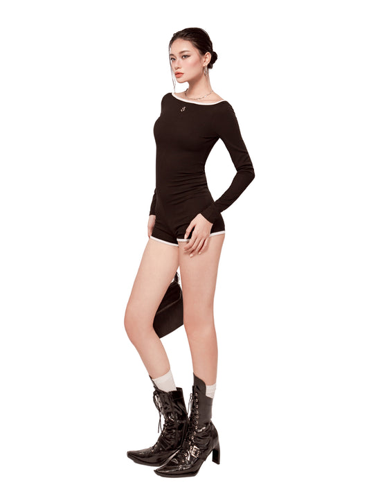 Woman wearing a black bodysuit and high-heeled boots on a white background