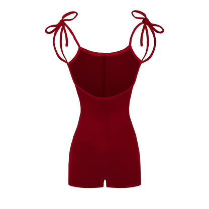 Red romper with bow straps on a white background