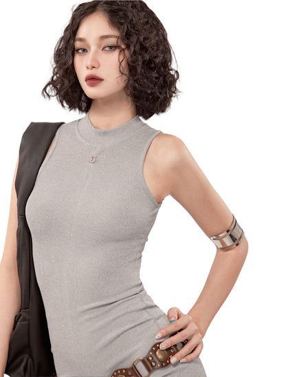 Woman wearing a gray sleeveless dress with a white background